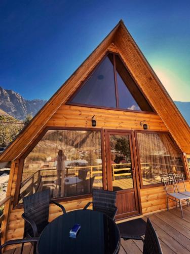 a cabin with a large window on a deck at Cottage Nishi in Stepantsminda