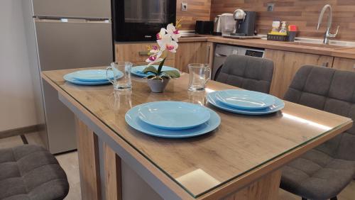 a table with blue plates and glasses on it in a kitchen at Апартамент Relax in Smolyan