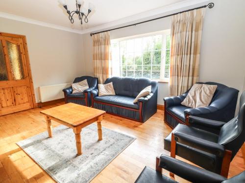 a living room with two couches and a table at Fernwood in Killarney