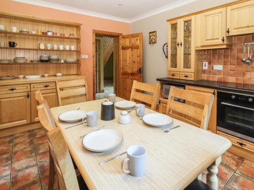 a kitchen with a wooden table with plates on it at Fernwood in Killarney