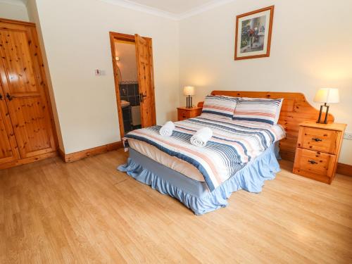 a bedroom with a bed and a wooden floor at Fernwood in Killarney