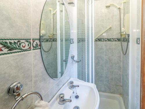 a bathroom with a sink and a mirror and a tub at Fernwood in Killarney