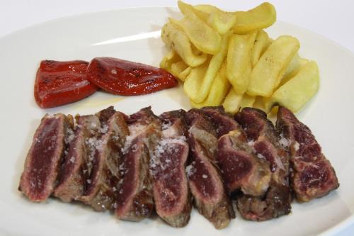 a plate of food with meat and french fries at Hotel El Juglar in Olite