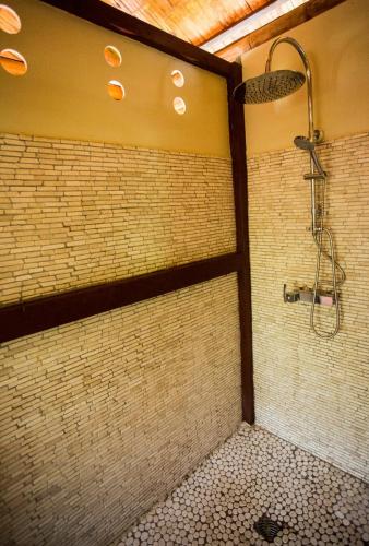 a bathroom with a shower in a brick wall at Shuit Bambou in La Trinité