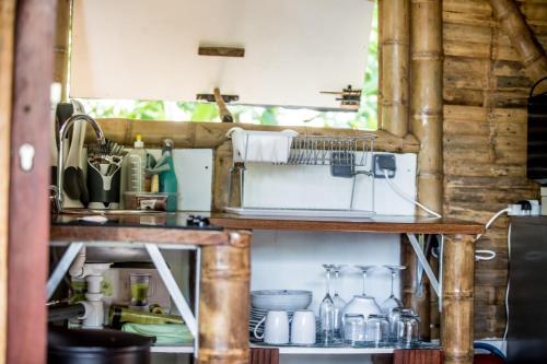 a kitchen with wooden shelves and a microwave at Shuit Bambou in La Trinité