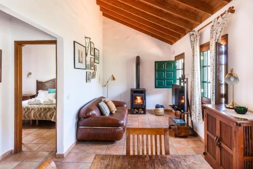a living room with a leather couch and a fireplace at Las Casas del Chorro in Agulo