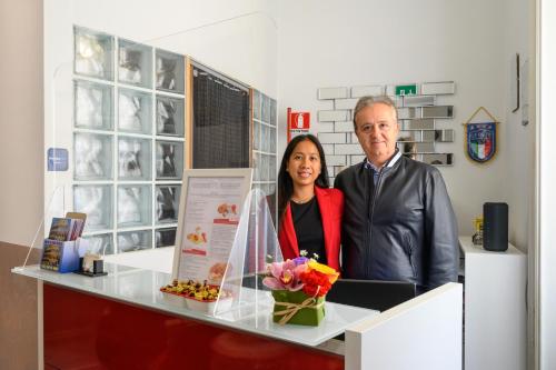 a man and a woman standing behind a counter at Cola Di Rienzo Suite Guest House in Rome