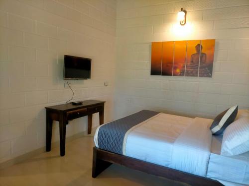a bedroom with a bed and a desk and a television at Coffeeberry Hills Chikamagalur in Chikmagalūr