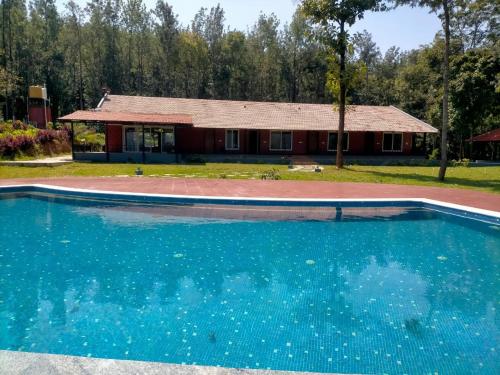 an empty swimming pool in front of a house at Coffeeberry Hills Chikamagalur in Chikmagalūr