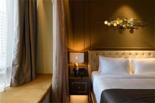 a hotel room with a bed and a chandelier at The Granite Luxury Hotel Penang in George Town