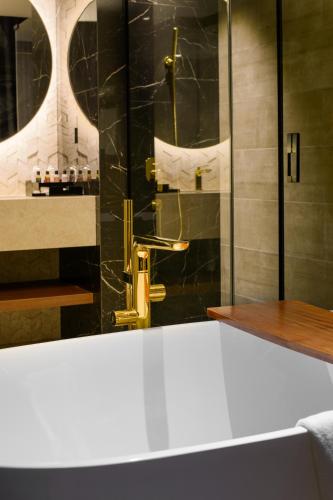 a bathroom with a shower with a sink and a toilet at The Granite Luxury Hotel Penang in George Town