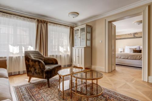 a living room with a chair and a table and a bed at Hotel Nerudova 211 in Prague
