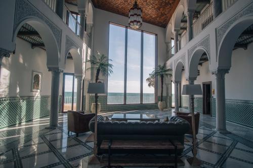 a living room with a couch and a large window at Apartamentos Turísticos La Baílla in Rota