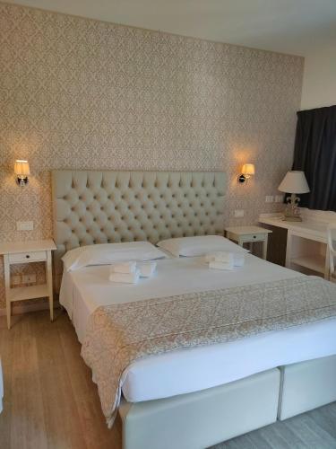 a bedroom with a large bed and two tables at Nuova Opera Rooms in Verona