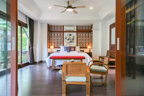 ein Schlafzimmer mit einem Bett, einem Tisch und Stühlen in der Unterkunft Cascade Tara in Na Mueang