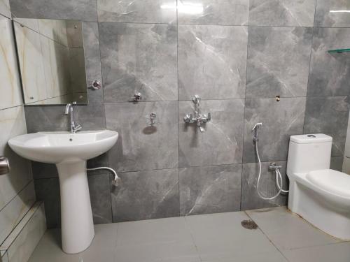 Hotel Crown Inn في دهرواد: حمام مع حوض ومرحاض