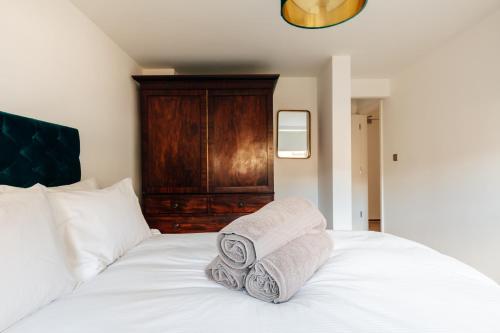 a white bed with towels on top of it at Charlecote House in Bath