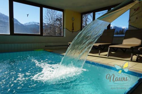 a water fountain in a swimming pool at nawu apartments & Restaurant in Hermagor