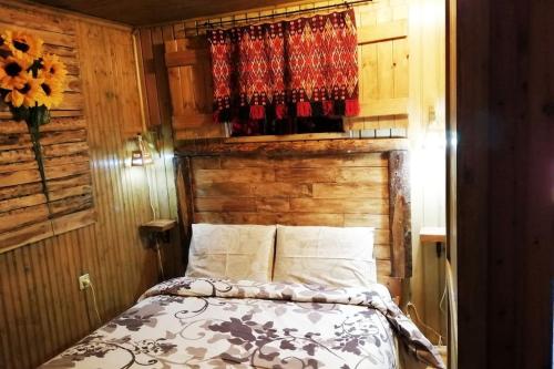 1 dormitorio con 1 cama con pared de madera en Sweet Home, en Neraidochori