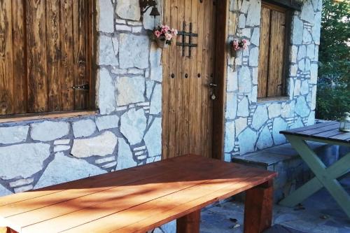 a wooden bench sitting in front of a stone wall at Sweet Home in Neraïdochóri