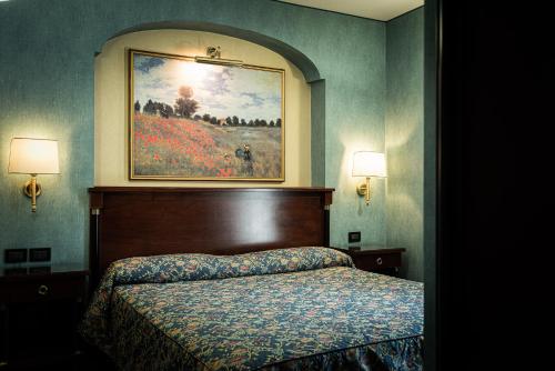 a bedroom with a bed and a painting on the wall at Hotel Petite Fleur in Roccaraso