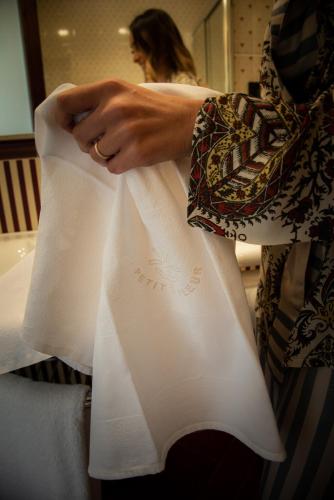 a woman is holding a white towel at Hotel Petite Fleur in Roccaraso