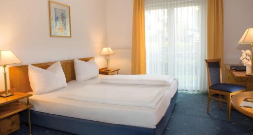 um quarto de hotel com duas camas e uma janela em Victor's Residenz-Hotel Gummersbach em Gummersbach