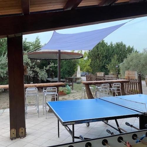 a ping pong table and an umbrella on a patio at Agriturismo San Michele in San Michele