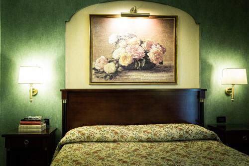 a bedroom with a painting of a vase of flowers at Hotel Petite Fleur in Roccaraso