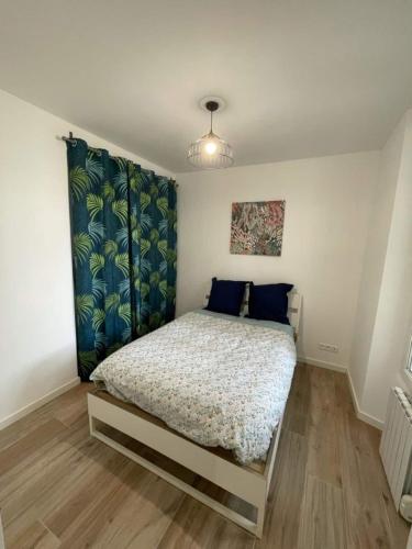 a bedroom with a bed and a blue curtain at L'encre - T2 4 Personnes - Port 2' Plage10' in La Seyne-sur-Mer