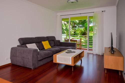 a living room with a couch and a table at Lido Gardens Funchal in Funchal