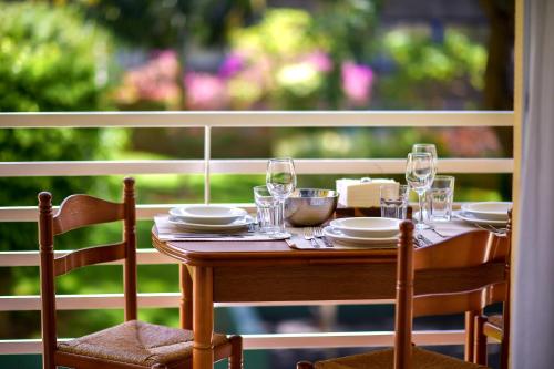 a wooden table with plates and glasses on a porch at Lido Gardens Funchal in Funchal