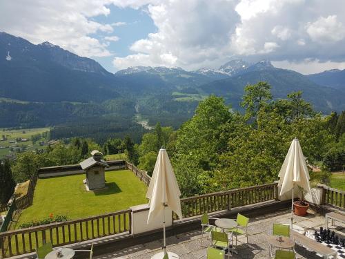 two white umbrellas sitting on a balcony with mountains at nawu apartments & Restaurant in Hermagor