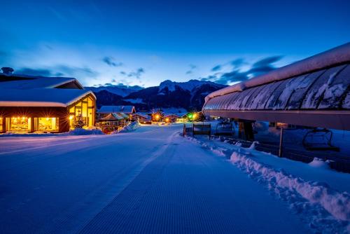 a snow covered street at night with a building at Boutique Hotel Pellas in Vella