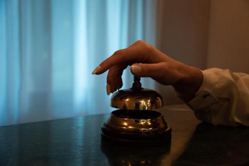 a hand holding a bell on top of a table at Hotel Petite Fleur in Roccaraso