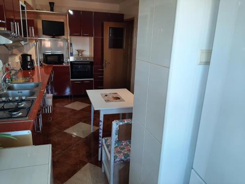 a small kitchen with a table and a stove at Ultracentral,Parcul Catedralei,apartament 2 camere in Bacău