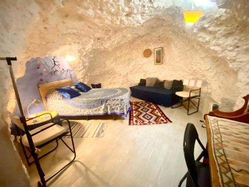 ein Schlafzimmer in einer Höhle mit einem Bett und Stühlen in der Unterkunft Cueva con vistas a la Alhambra in Granada