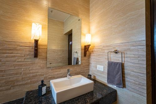 a bathroom with a sink and a mirror at Luxurious Villa with Private Swimming Pool, Kids Pool, Games, Private Parking in Calangute