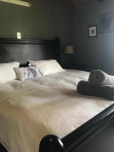 a large bed with white sheets and pillows on it at Kruger Ranch in Magaliesburg