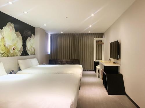 pokój hotelowy z 2 łóżkami i telewizorem w obiekcie Wholesome Hotel w Tajpej