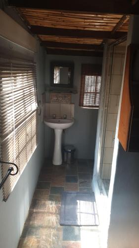 a bathroom with a sink and two windows at Kruger Ranch in Magaliesburg