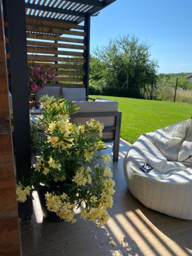 eine Terrasse mit einem Bett, Blumen und einer Bank in der Unterkunft D&N Apartments Синеморец in Sinemorets