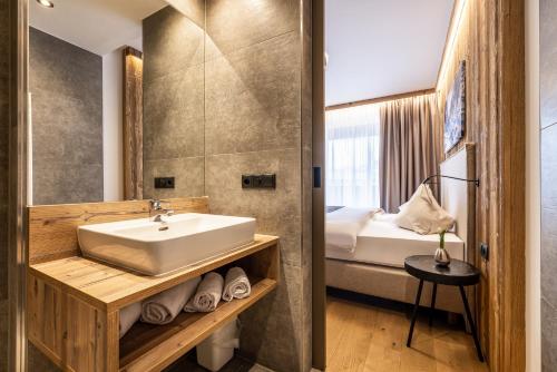 a bathroom with a sink and a bed at Ferienanlage Central in Flachau