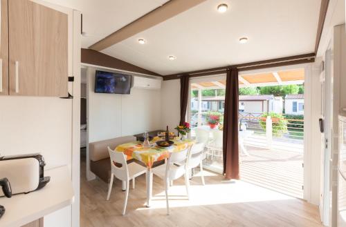 a kitchen and dining room with a table and chairs at Villaggio Turistico Internazionale in Bibione