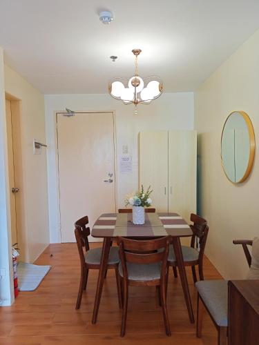 a dining room with a table and chairs and a mirror at Spacious 36sqm Studio with 65" TV Netflix Karaoke and Pool Access Near Airport and Samal Ferry in Dasag