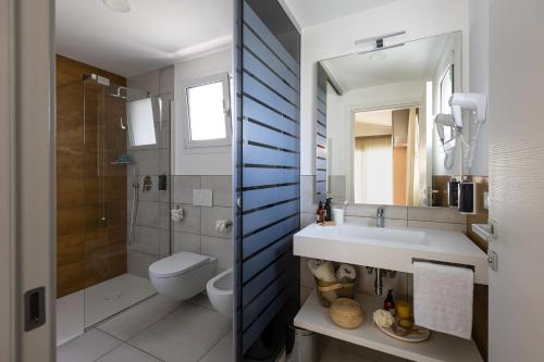 a bathroom with a sink and a toilet and a mirror at Villaggio Turistico Internazionale in Bibione