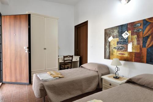 1 dormitorio con 2 camas y un cuadro en la pared en Casa Vacanze Bonu Iloghe, en Dorgali