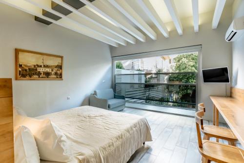 a bedroom with a bed and a large window at Palm Beach Hotel Apartments in Rethymno Town