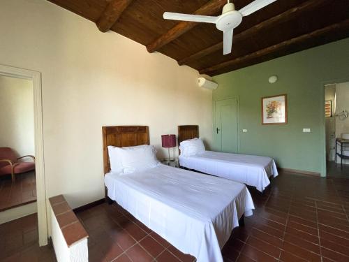 a bedroom with two beds and a ceiling fan at Agriturismo La Margherita in Carmagnola