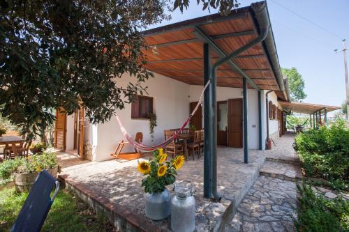 a house with a porch with a table and flowers at Agriturismo Fontetrilla in Orbetello